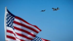 F-22 Raptor and P-51D Heritage Flight with American flag in foreground